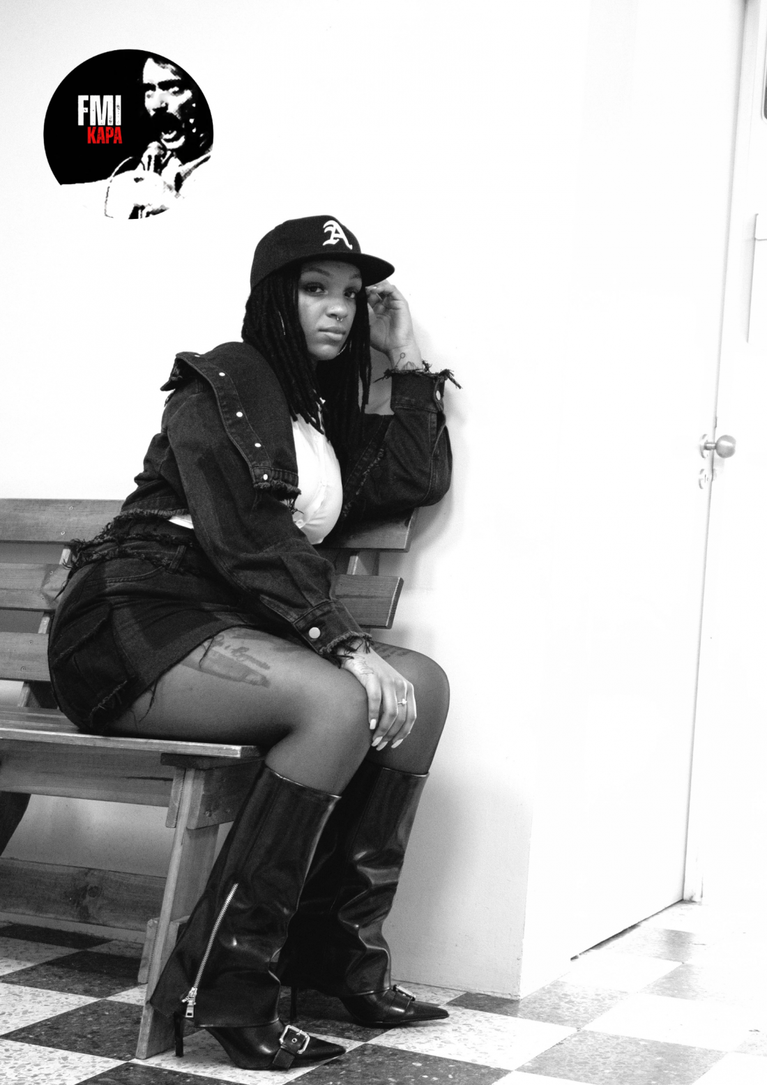 A preto e branco, uma mulher está sentada de lado num banco, encostada à parede, olhando na nossa direção. Na imagem, vê-se um selo no qual se lê “FMI KAPA”.
